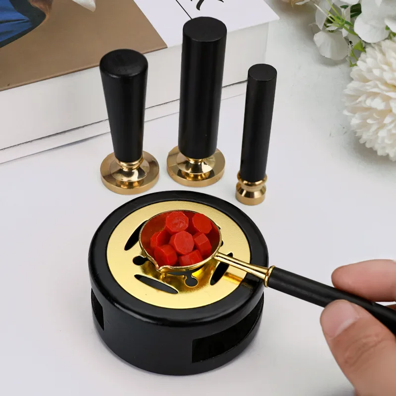 Wax warmer with melted wax in the spoon, next to stamp handles