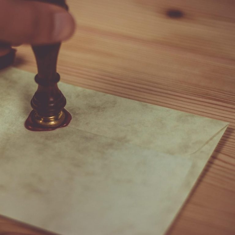A brass stamp pressed into soft sealing wax
